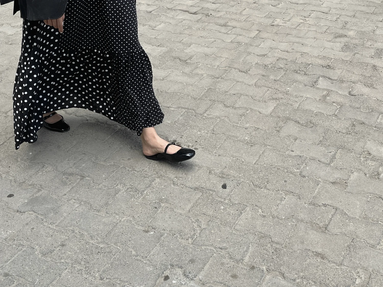 Cropped street photograph of a figure wearing a polka-dot skirt
